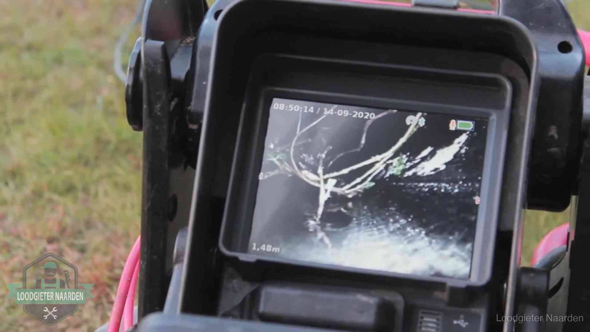 Monitor van een rioolcamera toont wortelingroei in de rioolbuis bij een woning in Naarden