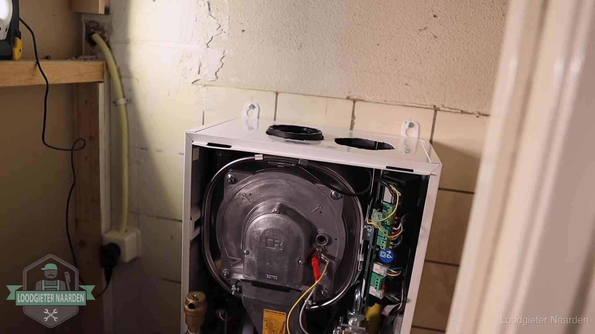 Geopende cv-ketel tijdens een onderhoudsbeurt in Naarden, met brander en warmtewisselaar zichtbaar