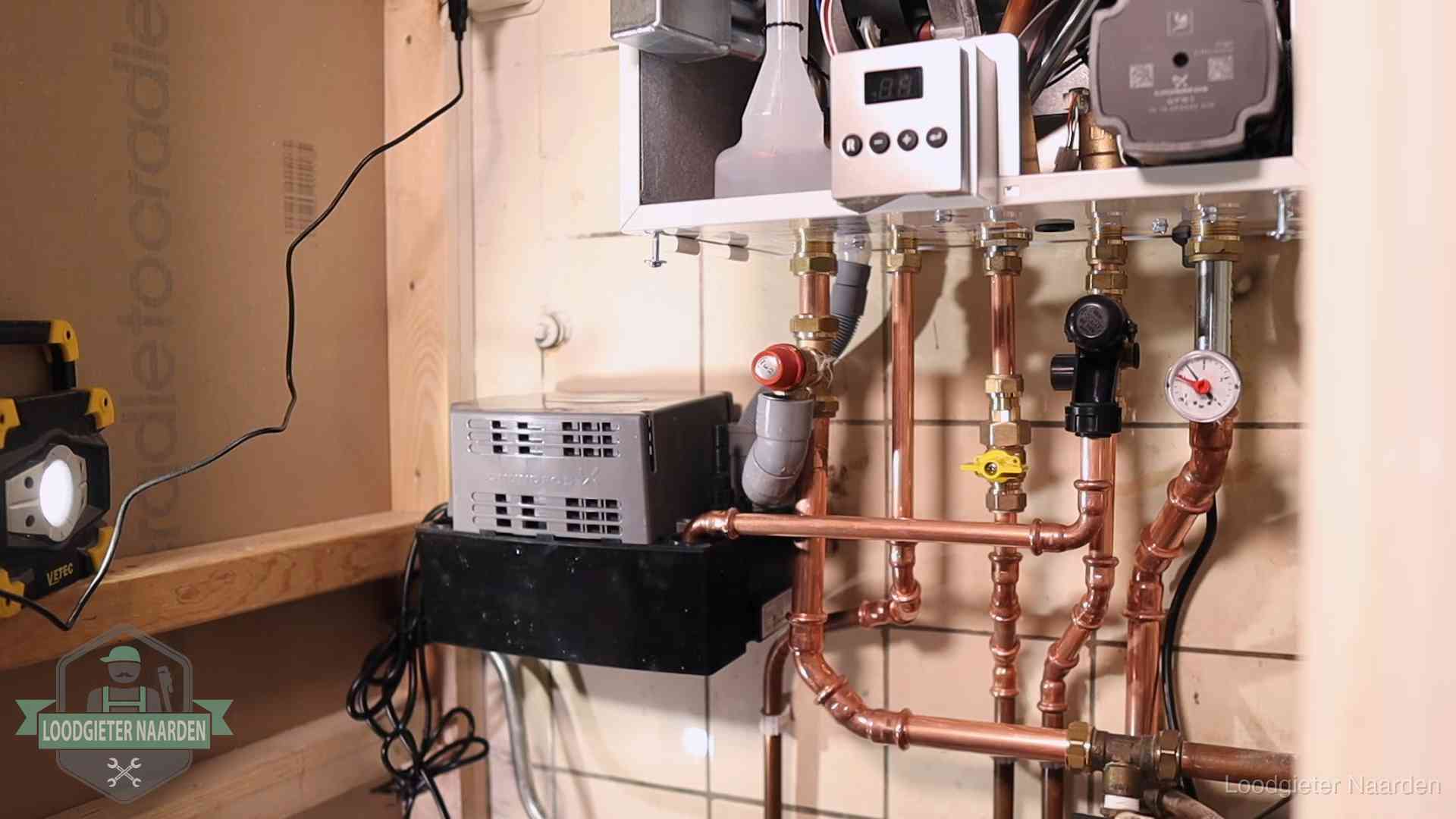 Nieuw koperen leidingwerk met pomp en manometer onder een vervangen cv-opstelling in Naarden