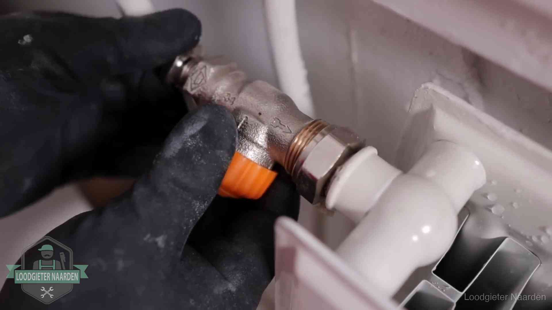 Thermostaatkraan wordt gemonteerd op een radiator in Naarden voor het stookseizoen