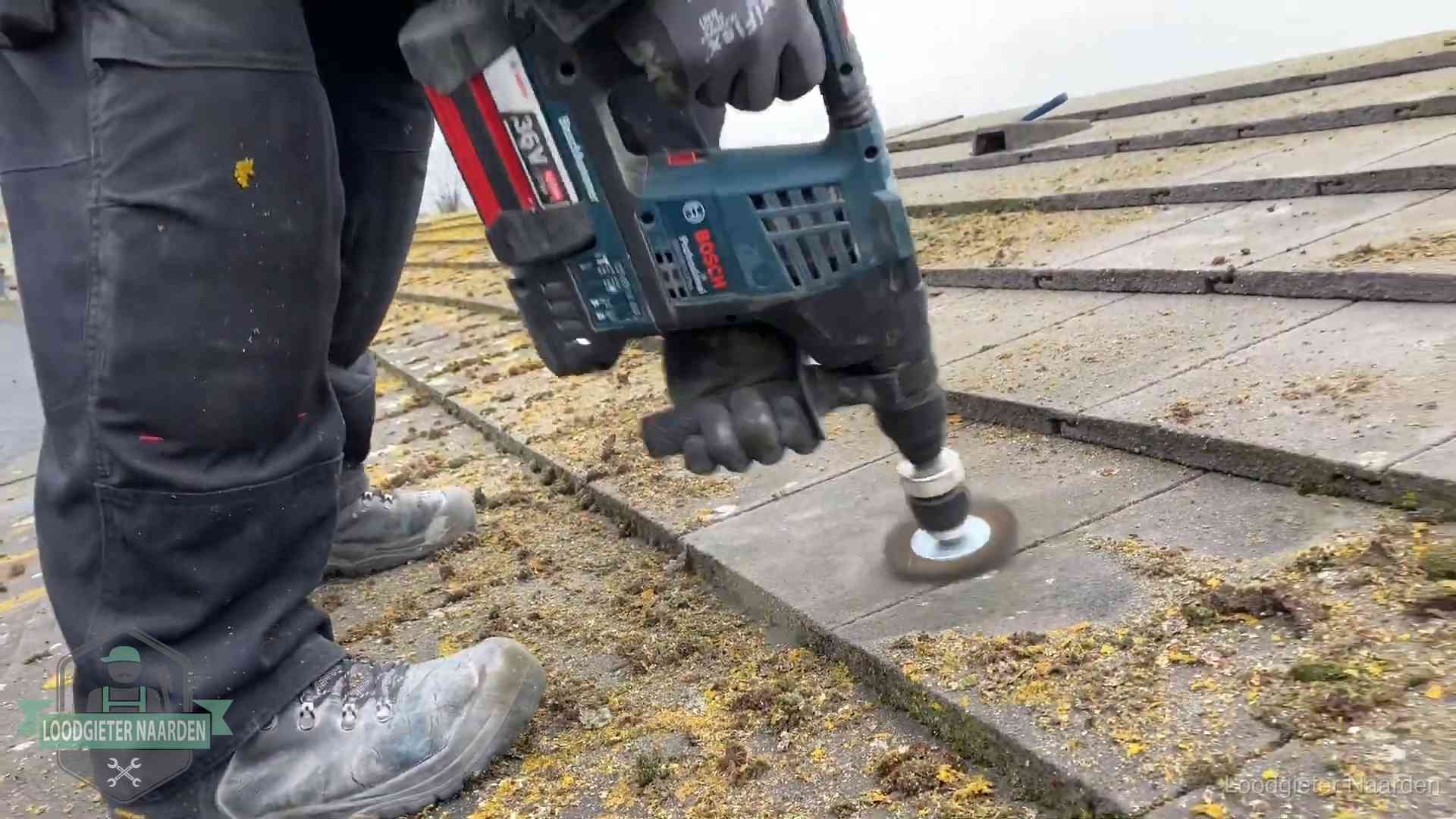 Dakonderhoud en preventie in Naarden Betonnen dakpannen worden machinaal gereinigd tijdens dakonderhoud in Naarden