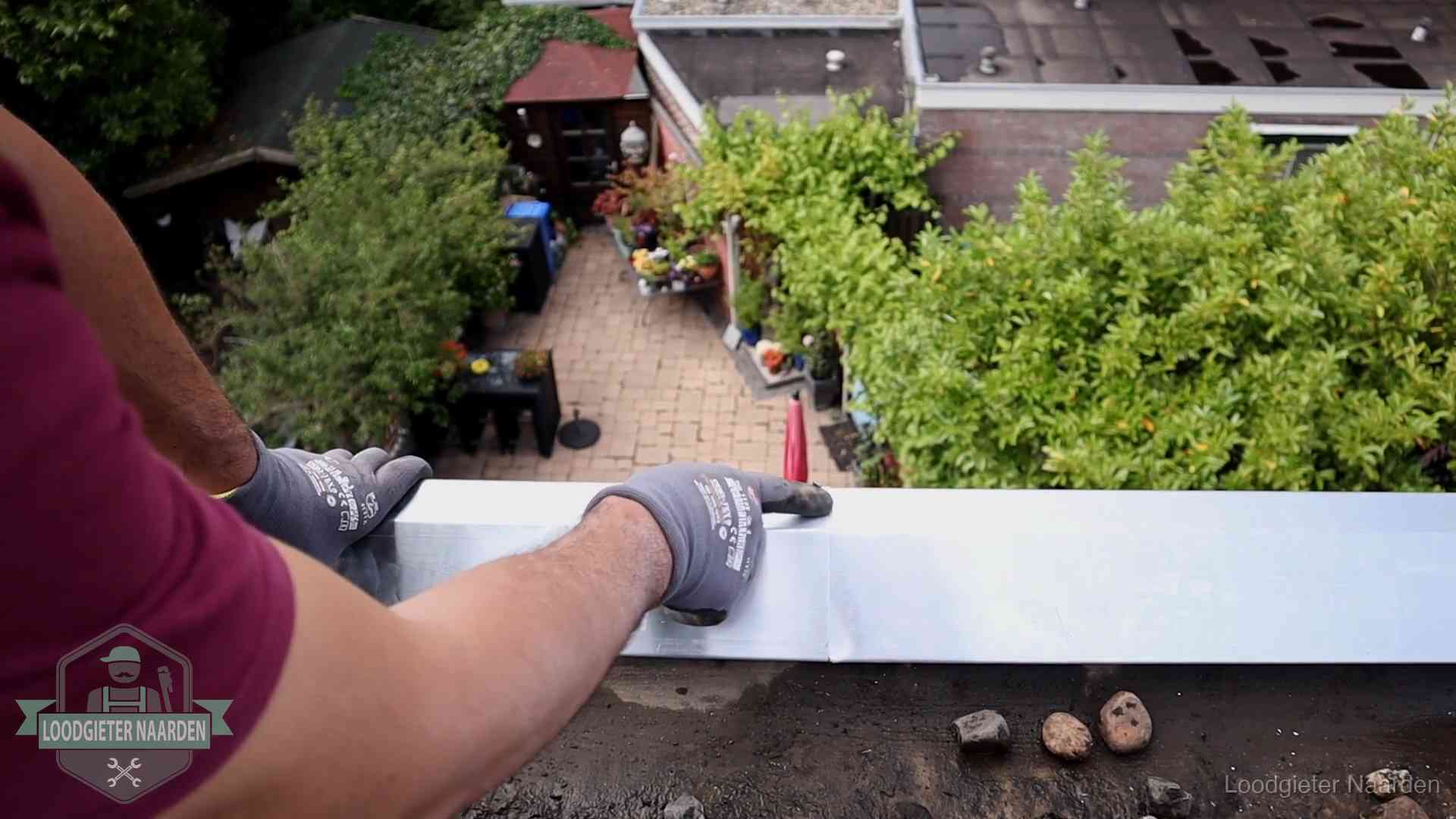 Daklekkage geregeld in Naarden Vakman plaatst een daktrim op de dakrand van een woning in Naarden