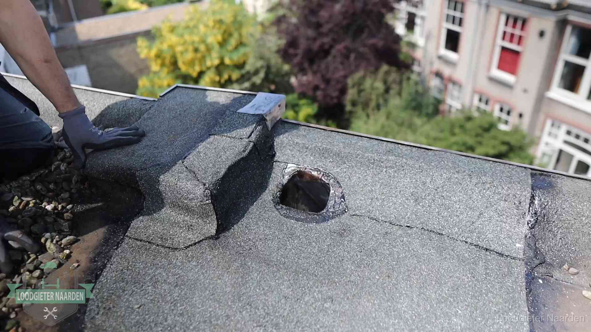 Daklekkage-inspectie op een plat dak in Naarden Loodgieter inspecteert een beschadigd bitumen plat dak tijdens een daklekkage-inspectie in Naarden