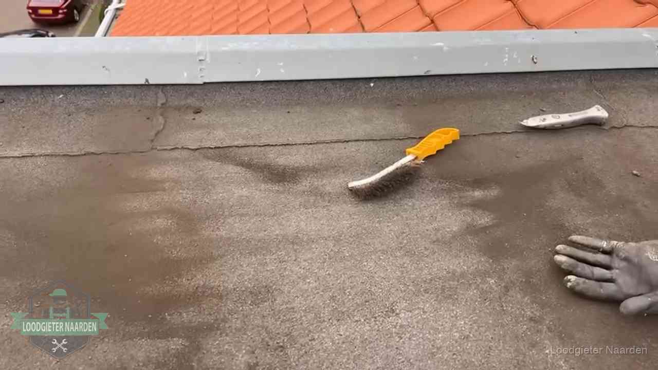 Kosten van daklekkage-reparatie in Naarden Dakdekker bereidt een bitumen plat dak voor op reparatie bij de daktrim in Naarden