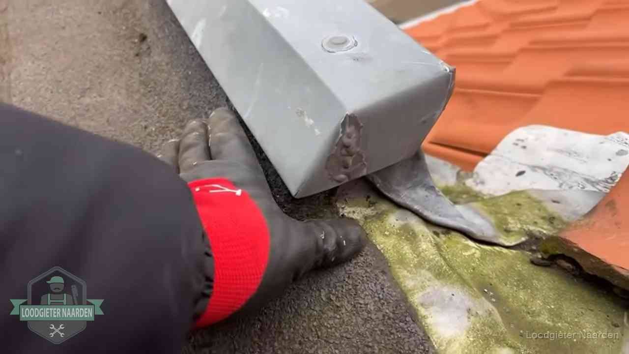 Hemelwaterafvoer en dakgoot controleren in Naarden Controle van een zinken hemelwaterafvoer met loodslab bij dakpannen in Naarden