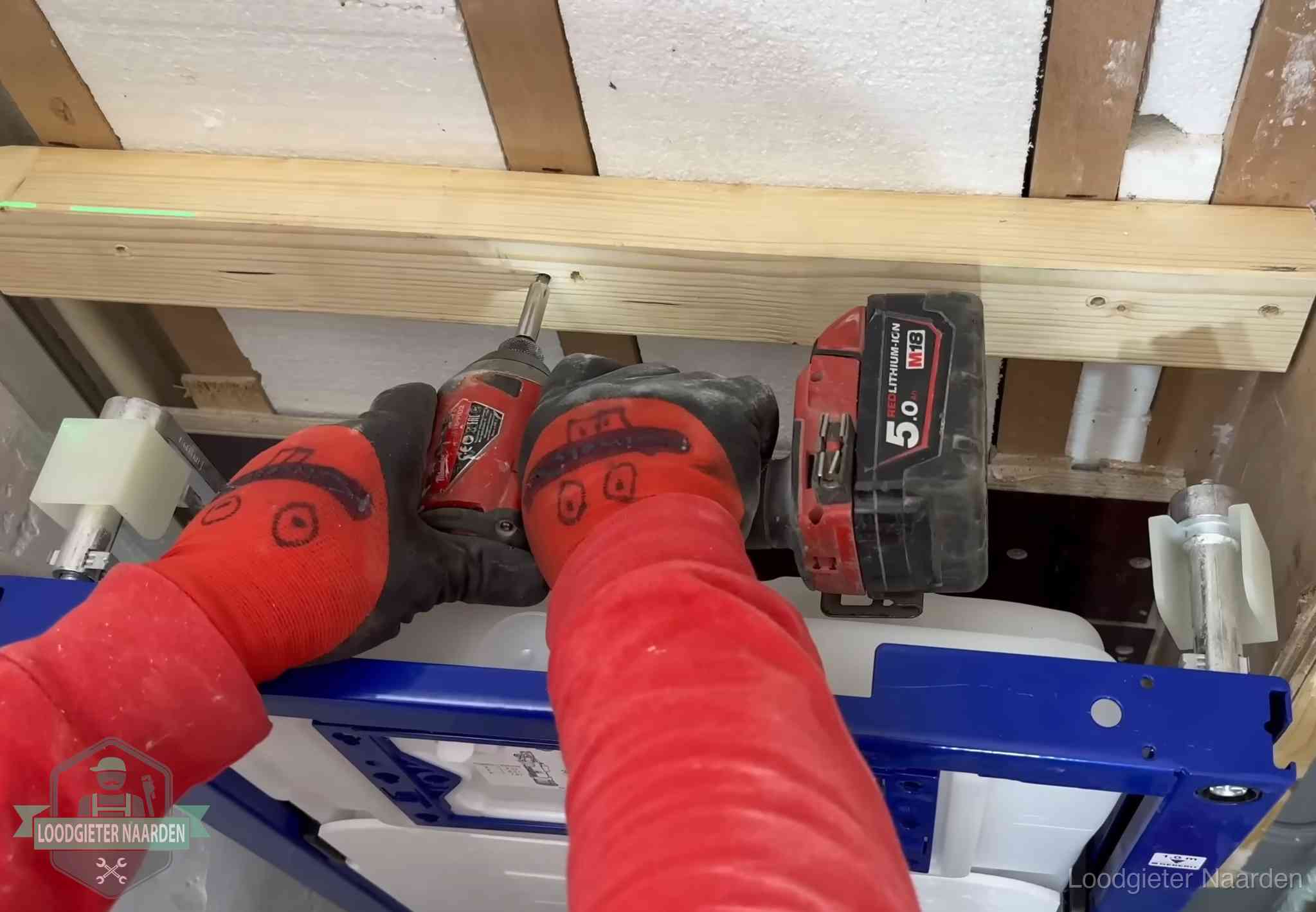 Monteur bevestigt een inbouwreservoir voor een hangend toilet in Naarden