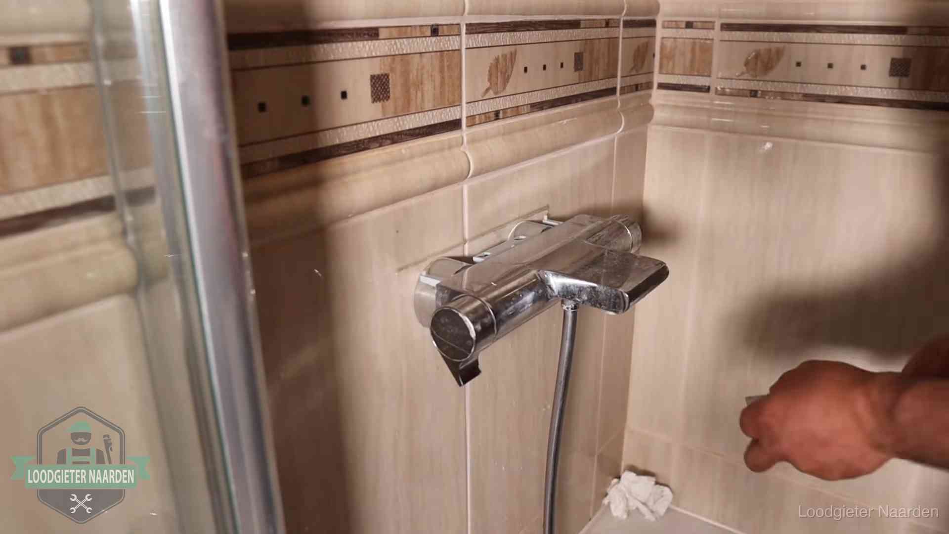 Verkalkte douche-mengkraan in Naarden, hetzelfde kalk dat zich in de warmtewisselaar afzet