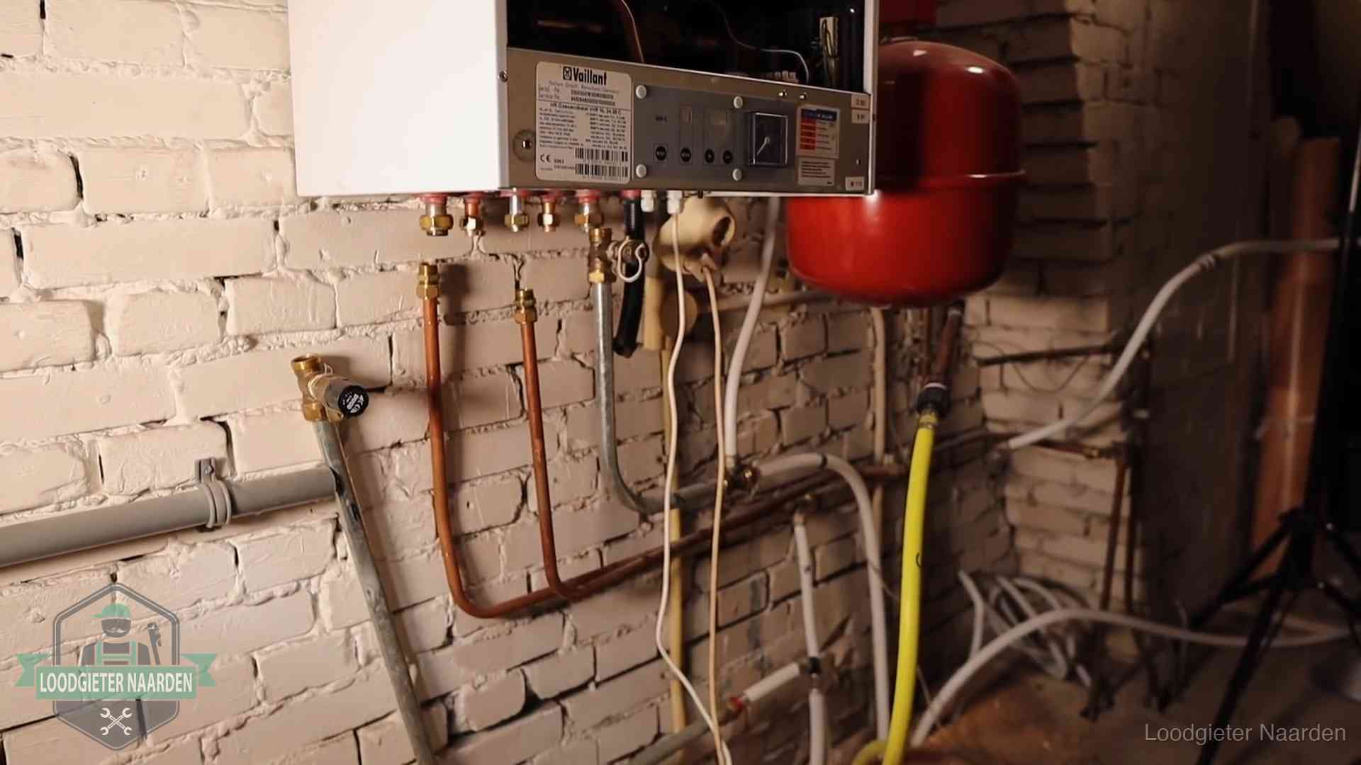Verouderde cv-ketel met een wirwar van oude leidingen in een woning in Naarden