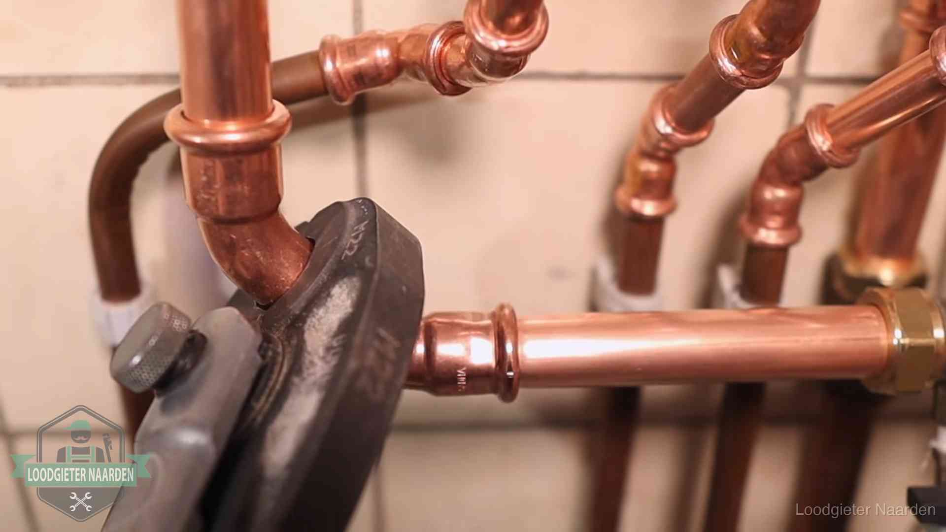 Werkwijze van ons loodgietersbedrijf in Naarden Persmachine perst een koperen fitting op nieuw leidingwerk in Naarden