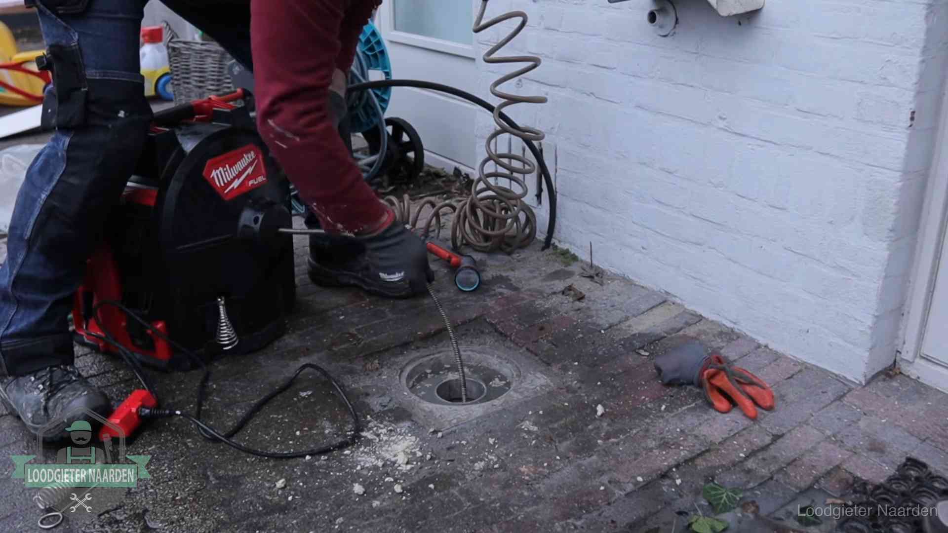 Spiraalmachine bij een ontstoppingsputje in de bestrating in Naarden