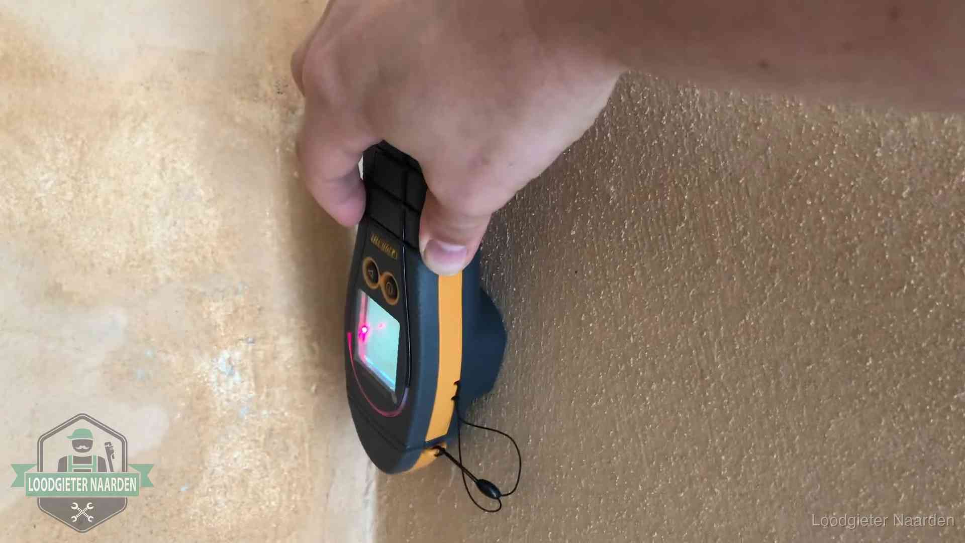 Daklekkage opsporen zonder hakwerk in Naarden Vochtmeter tegen een muur met vochtplekken tijdens het opsporen van een daklekkage in Naarden