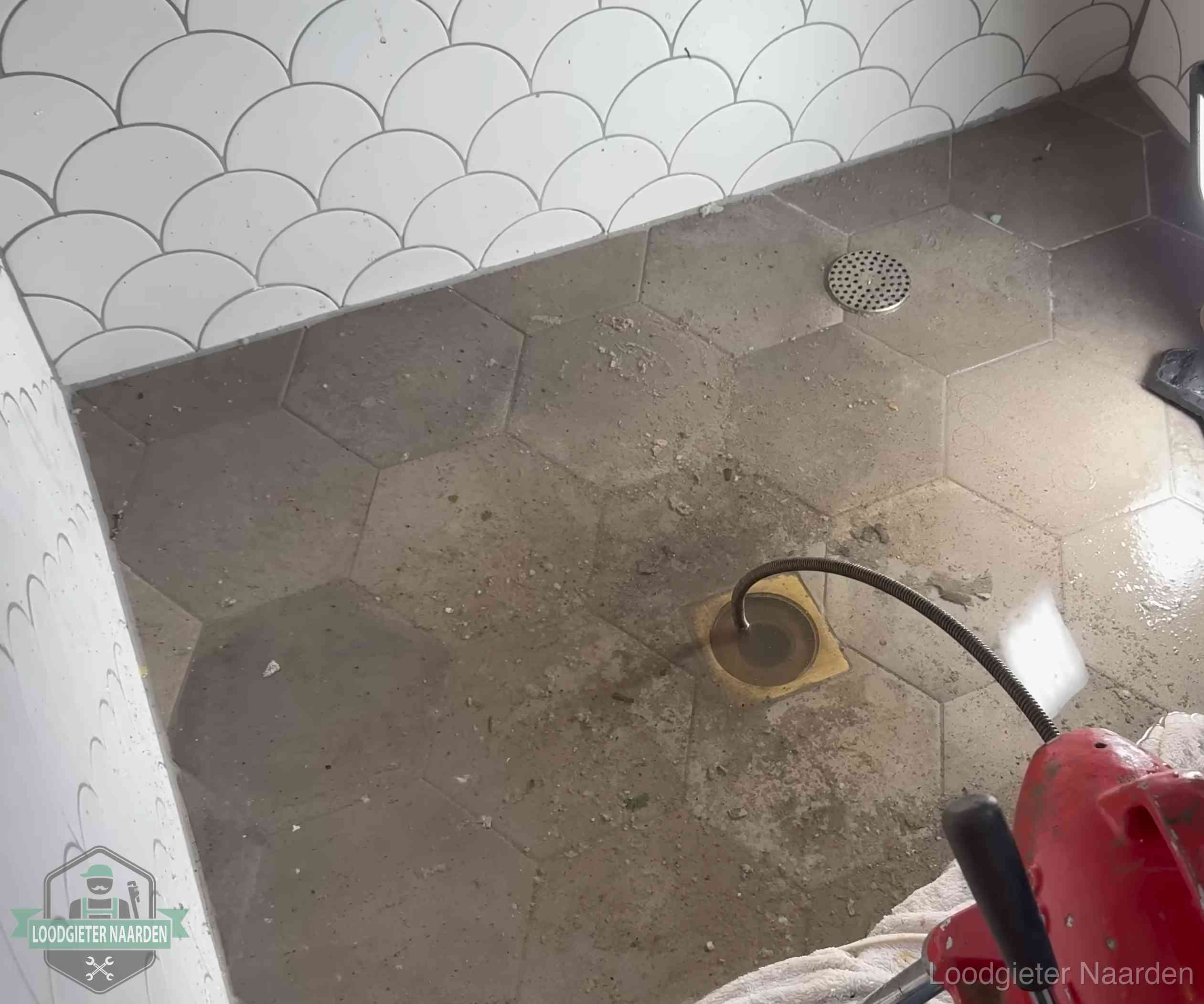 Vloerput met waterslot in een badkamer in Naarden, een bron van stank als het waterslot droogstaat