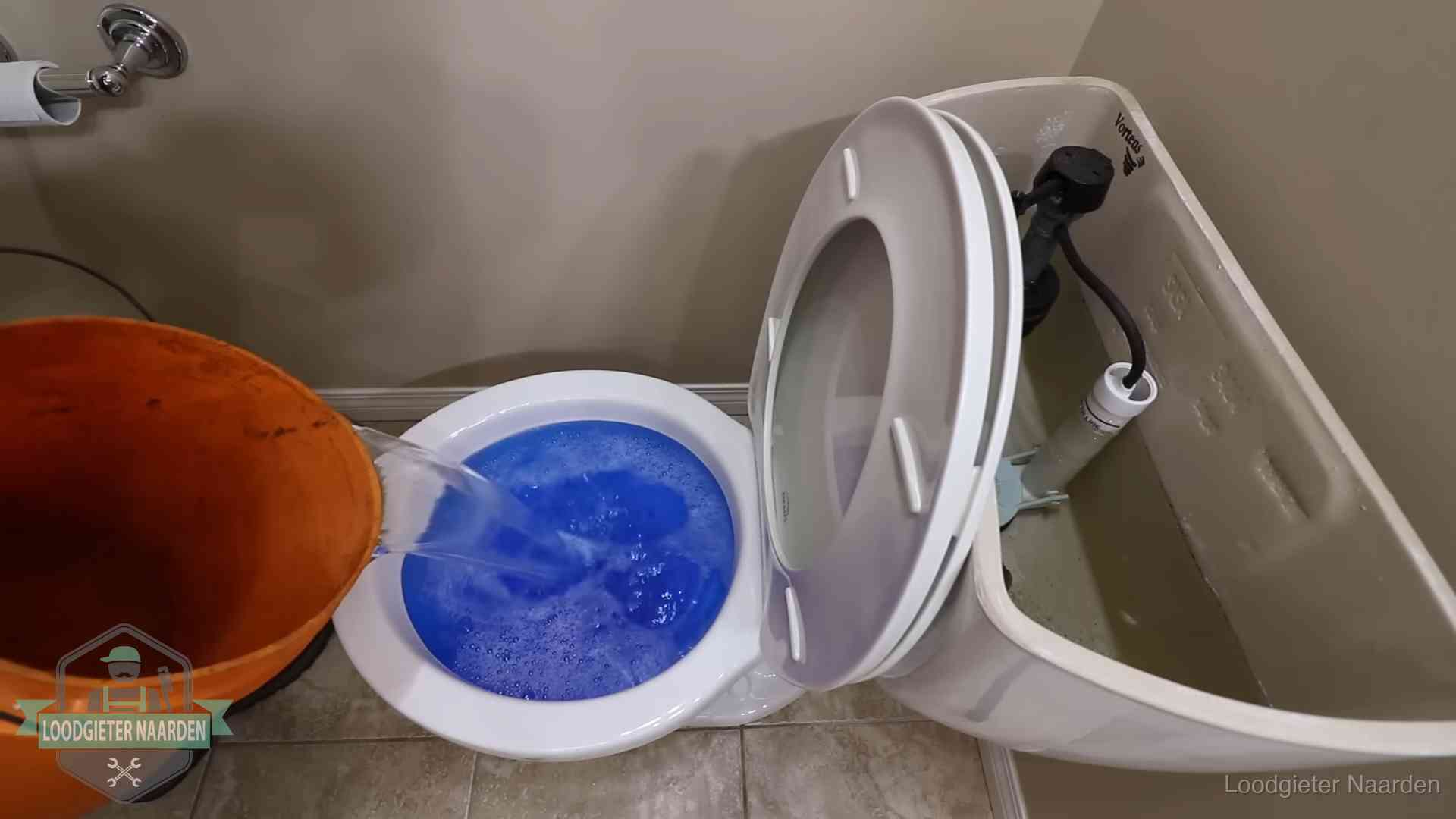 Water bij de wc-pot wordt met een emmer weggewerkt om schade te beperken in Naarden